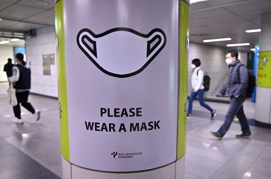 People walk past a poster showing precautions against Covid-19 at a subway station in Seoul on March 17, 2022. South Korea leads the world in the daily average number of new cases, according to a Reuters analysis.
