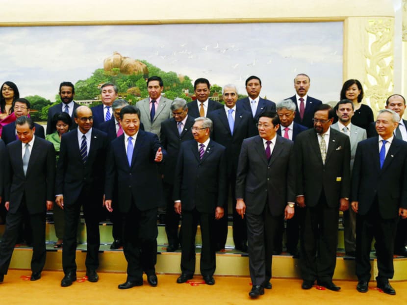 Mr Xi (front row, centre) and other leaders, including Singapore’s Finance Minister Tharman Shanmugaratnam (front row, fourth from left), at the AIIB launch ceremony in Beijing last year. Photo: Reuters