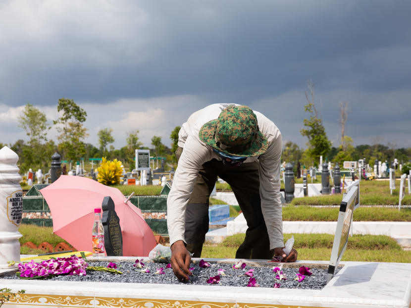 Mr Rohaizat Roza placing flowers on a grave at a Muslim cemetery in Lim Chu Kang on May 22, 2020.