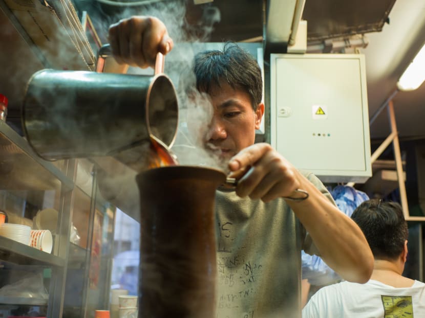 In this picture taken on August 10, 2016 a tea master makes a milk tea, or "lai cha" -- a tangy, deep-tan brew made from blends of black tea strained repeatedly through a sock-like strainer, at family-run tea shop Lan Fong Yuen, on a hilly market street in Hong Kong's Central district.  AFP file photo