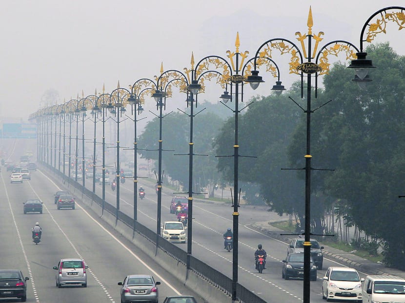Motorists driving amid haze yesterday in Klang, outside Kuala Lumpur. PHOTO: AP