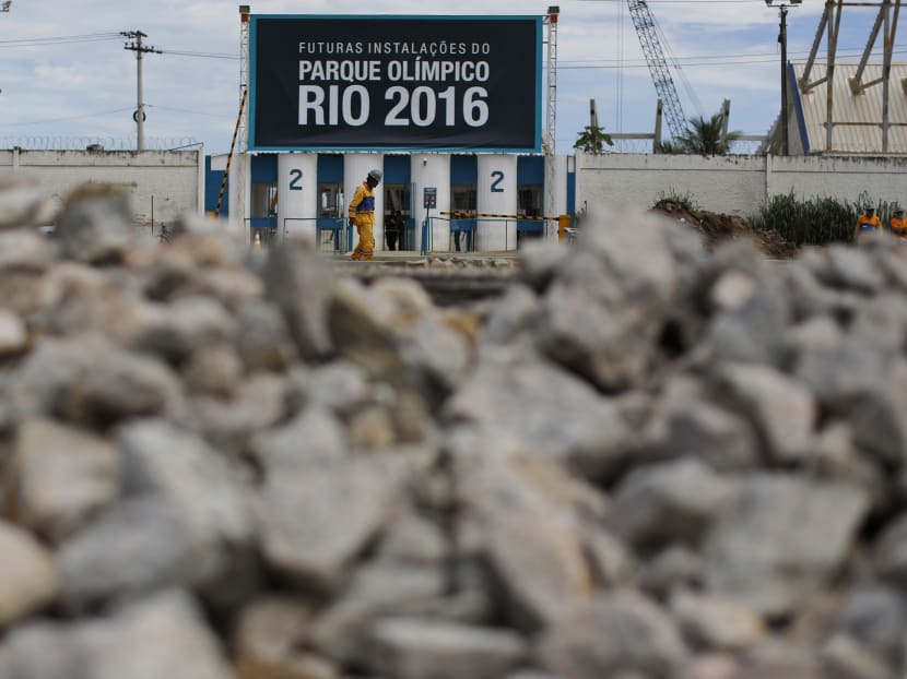 A worker walks past one of the entrances of the Olympic Park, that reads in Portuguese "Future facilities of the Olympic Park Rio 2016," in Rio de Janeiro, Brazil. Photo: AP