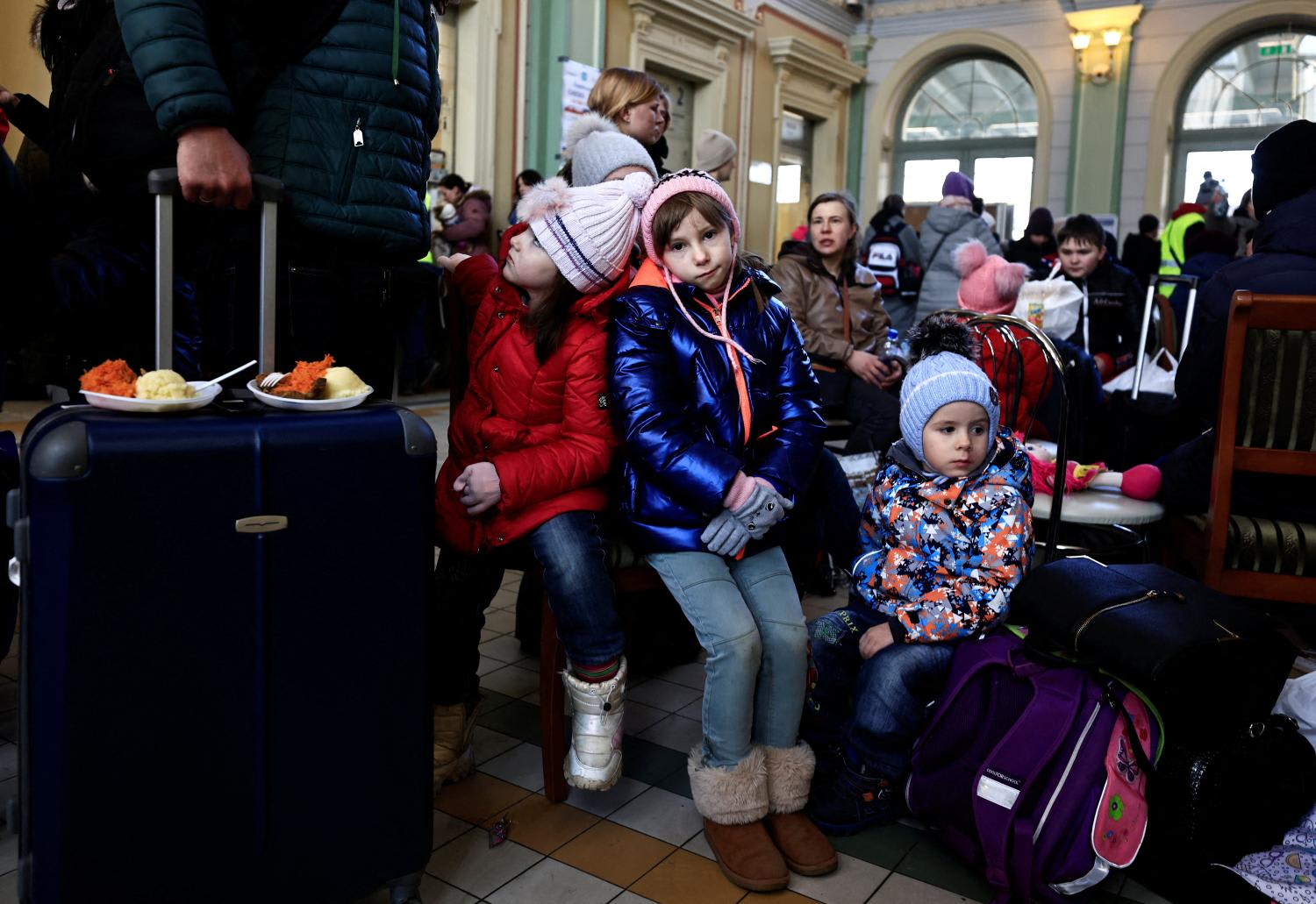 Girls rest at a train station, after fleeing Russia's invasion of Ukraine, in Przemysl, Poland, March 17, 2022.