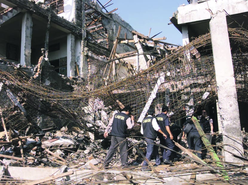 Indonesian forensic police walk through a destroyed building at the site of a bomb blast in Kuta beach on the resort island of Bali in this October 13, 2002 file photo. Photo: Reuters
