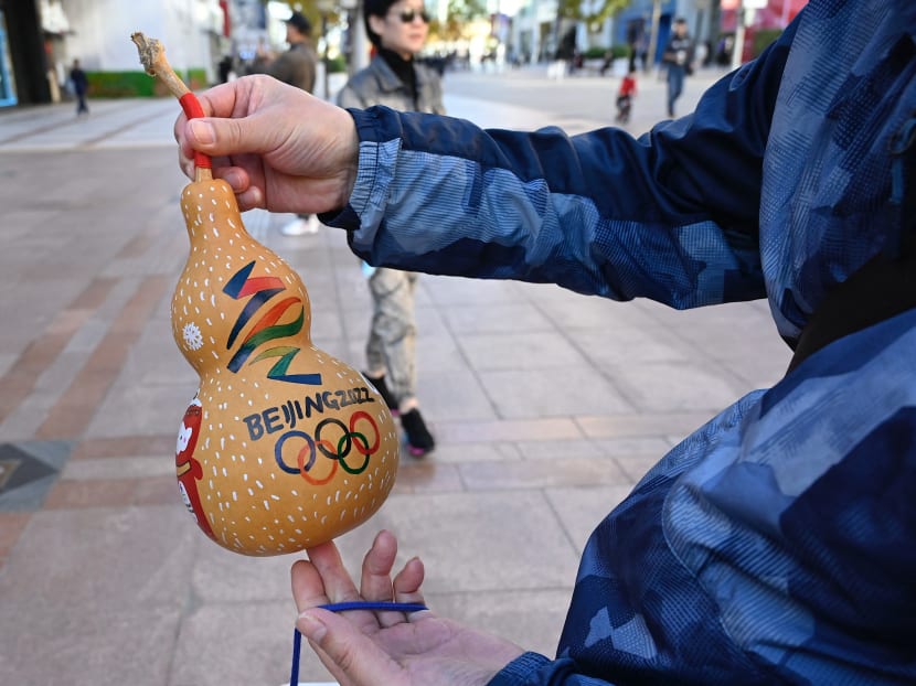 A man shows a gourd depicting the logo of 2022 Beijing Winter Olympics Games, at a shopping mall complex in Beijing on Oct 27, 2021.