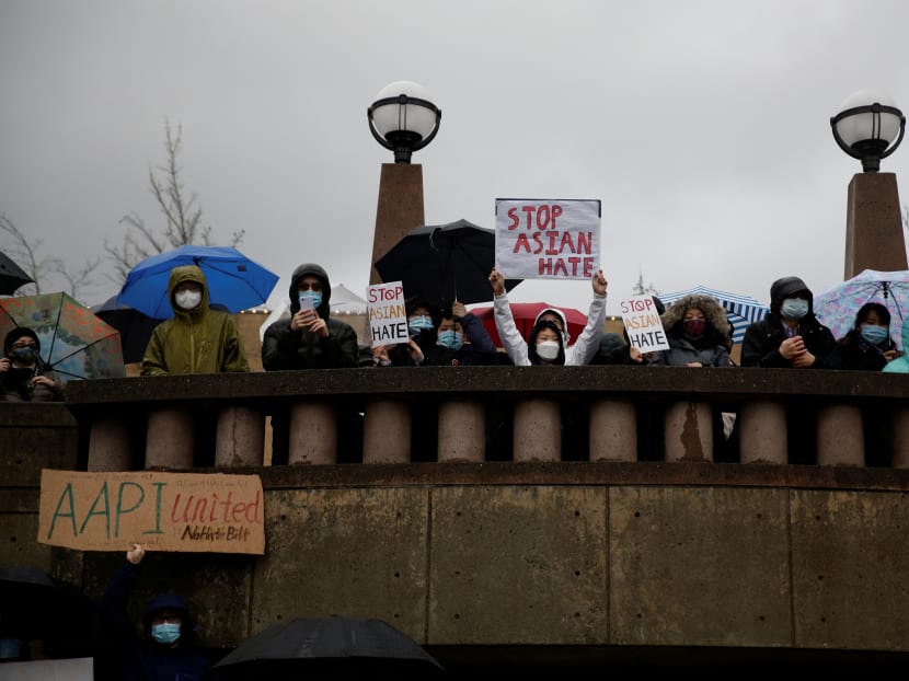 People listen to speakers in the rain during a "Stop Asian Hate" rally and vigil to remember the Atlanta shooting victims at Bellevue Downtown Park in Bellevue, Washington, US, on March 20, 2021.