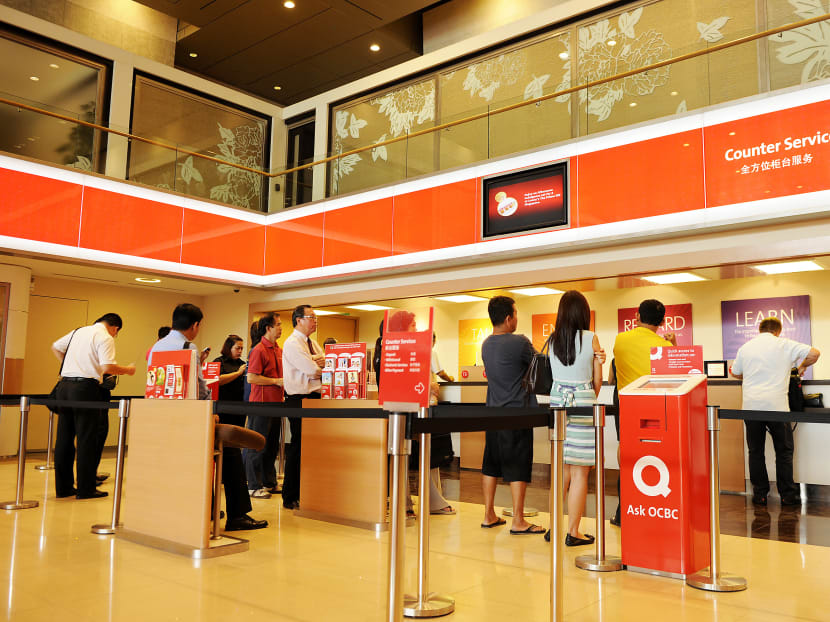 Customers queue at a service counter at Oversea-Chinese Banking Corp.'s (OCBC) main branch in Singapore. Photo: Bloomberg