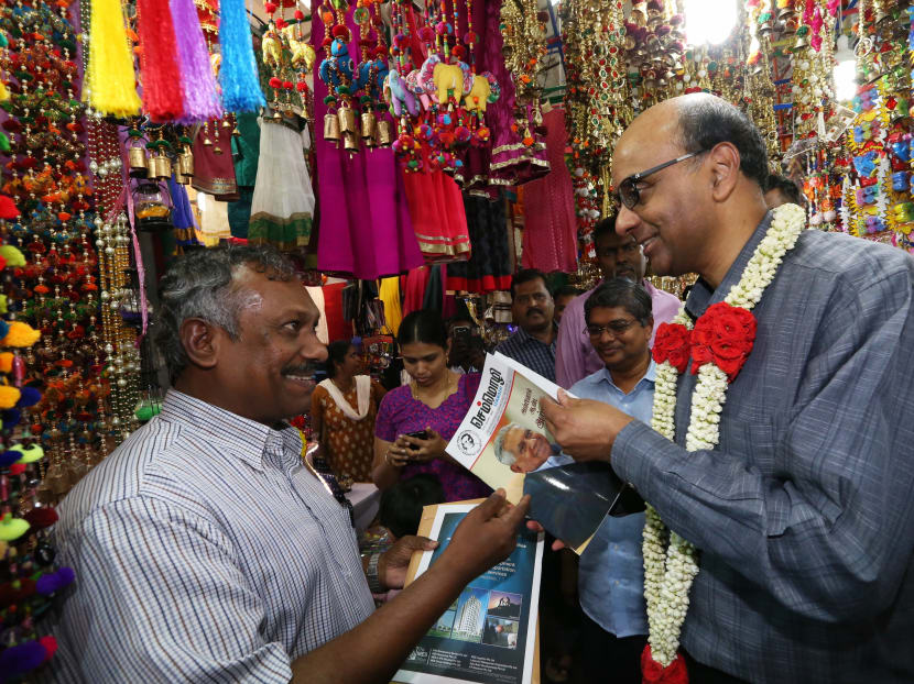 Deputy Prime Minister Tharman Shanmugaratnam is presented with a copy of a magazine featuring the late Mr S R Nathan on its cover, as he walks the Deepavali Village in Little India to visit the SINDA booth on Oct 20, 2016. Photo: Ooi Boon Keong/TODAY