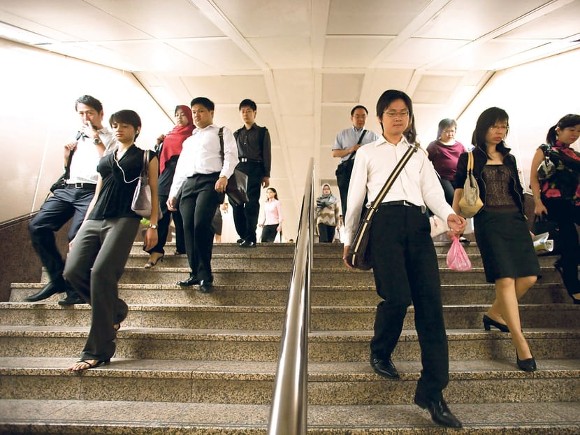 Office workers arrive for work in the central business district of Singapore. Bloomberg file photo
