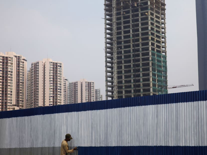 A worker paints a wall surrounding a new apartment block in Jakarta August 28, 2013. Photo: Reuters