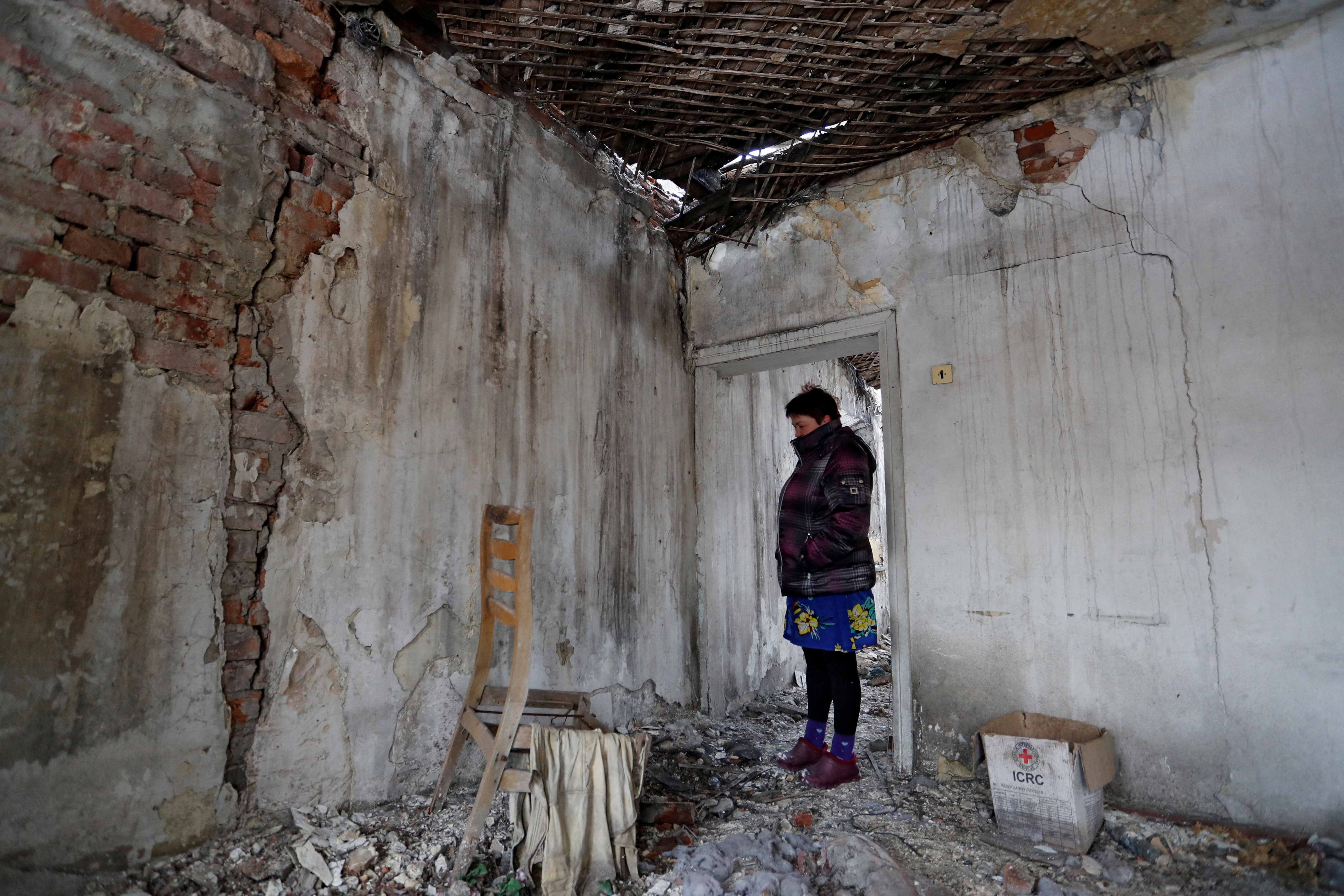 Local resident Svetlana stands inside her house that was destroyed few years ago during a military conflict between militants of the self-proclaimed Donetsk People's Republic and the Ukrainian armed forces in the village of Signalne in Donetsk region, Ukraine.