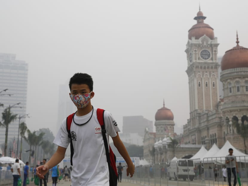 A Malaysian man wearing a mask walks past the Sultan Abdul Samad building shrouded with haze in Kuala Lumpur, Malaysia, Sunday, Oct. 4, 2015. Photo: AP