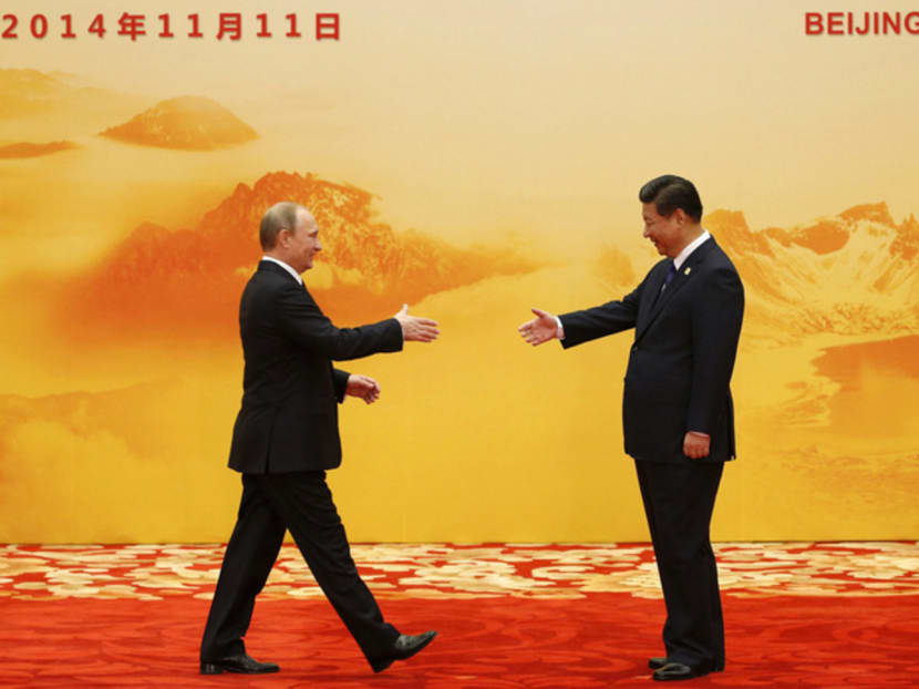 Russia's President Vladimir Putin (L) shakes hands with his Chinese counterpart Xi Jinping during the Asia Pacific Economic Cooperation (APEC) forum in Beijing, Nov 11. Photo: Reuters