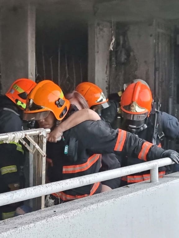 Firefighters rescuing a resident from an adjacent unit on the fourth floor of Block 409, Bedok North Avenue 2 on May 13, 2022.