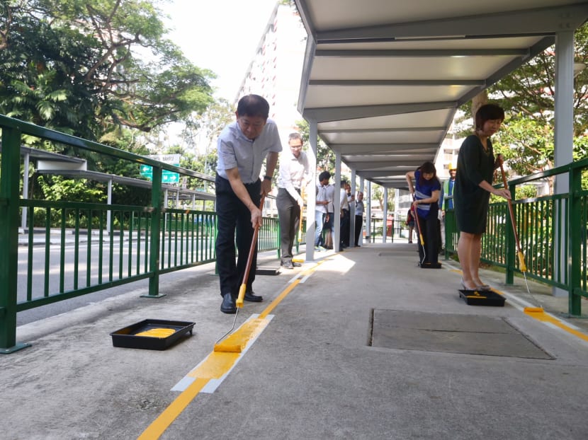 Transport Minister Khaw Boon Wan applying the finishing touches on the enhancements to the walking infrastructure along the 400m route between Redhill station and the Enabling Village. Photo: Koh Mui Fong/TODAY