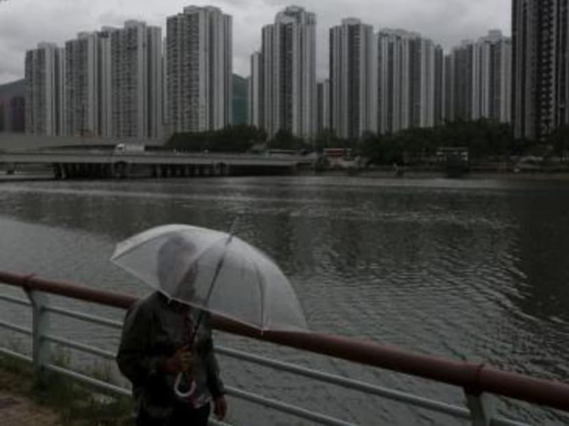 A passer-by walks along a riverside as City One Shatin residential precinct is seen at background in Hong Kong, China. Photo: Reuters A passer-by walks along a riverside as City One Shatin residential precinct is seen at background in Hong Kong, China. Photo: Reuters