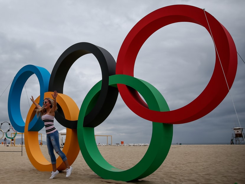 A woman poses with the Olympic Rings after its inauguration ceremony at the Copacabana Beach ahead 2016 Rio Olympics on July 21, 2016 in Rio de Janeiro, Brazil.  Photo: Getty Images