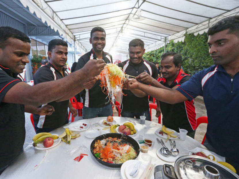 A group of foreign workers from Tamil Nadu, India try their hands at lohei at a reunion dinner hosted by The Hesed Table for migrant workers in recognition of their contribution to Singapore on Feb 22, 2016. The migrant guests were treated to a sumptuous Chinese New Year meal consisting of steamboat and an Indian-style buffet. Photo: Ooi Boon Keong
