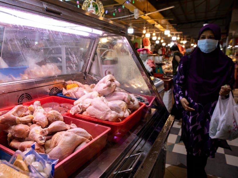 A woman walking past a poultry stall at a wet market in Yew Tee on May 25, 2022. A woman walking past a poultry stall at a wet market in Yew Tee on May 25, 2022.