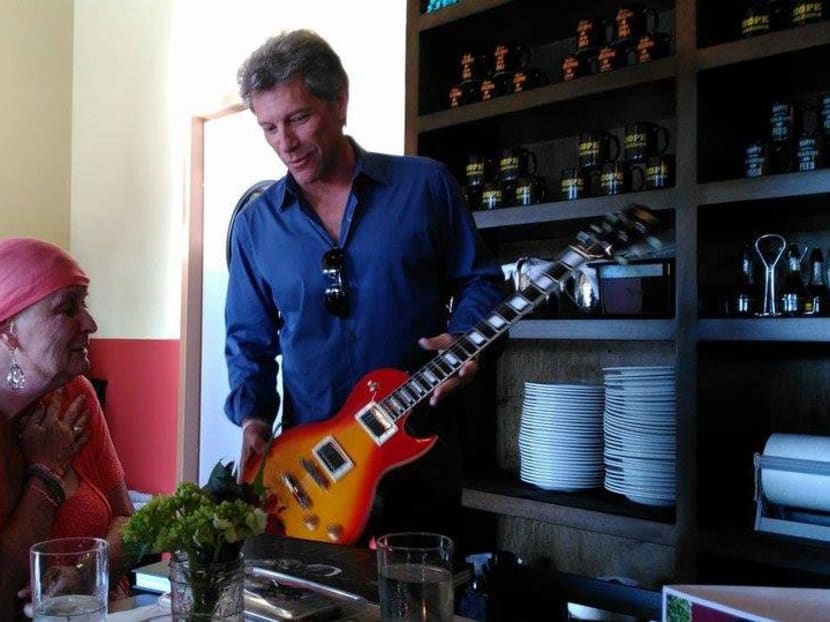 Jon Bon Jovi giving an autographed guitar to Carol Cesario. Photo: Rosie Skripkunis/Facebook