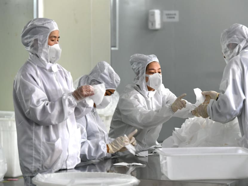Employees work on a production line manufacturing face masks at a factory, as the country is hit by an outbreak of the novel coronavirus, in Fuzhou
