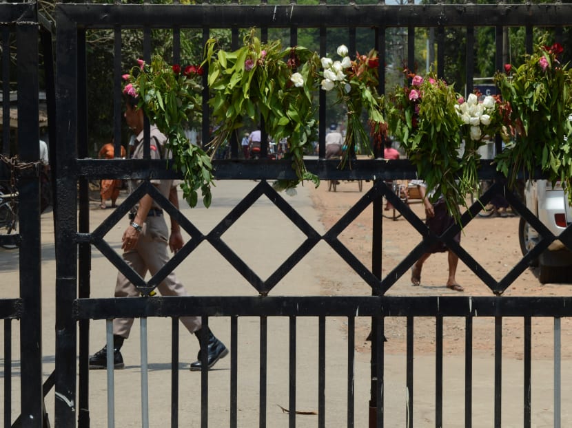 Flowers from relatives and sympathisers of political prisoners hang on the main gate of a prison in Yangon. AFP file photo