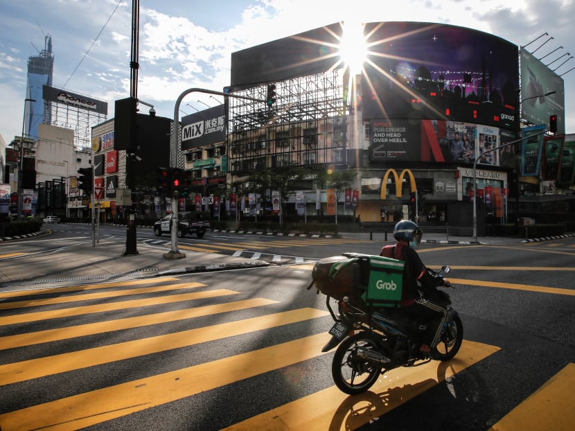 A food delivery man wearing a face mask rides on an empty street during the lockdown. A food delivery man wearing a face mask rides on an empty street during the lockdown.