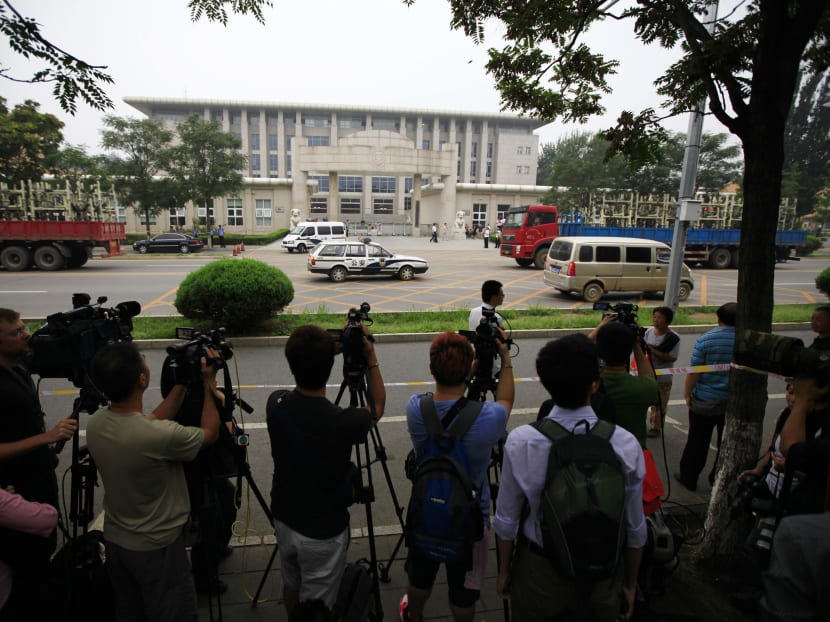 Journalists take pictures and videos within a restricted media area as they wait for the appeal verdict of Liu Hui outside a court in the Huairou district of Beijing August 16, 2013. Photo: Reuters