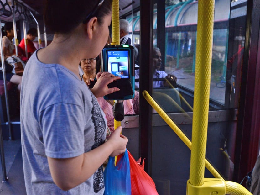 A public transport user tapping her EZ-Link card as she alighted the bus. Photo: Robin Choo