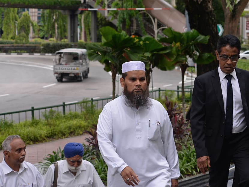 Imam Nalla Mohamed Abdul Jameel (centre), who made offensive remarks against Jews and Christians, at the State Courts with his lawyer (right). Photo: Robin Choo/TODAY
