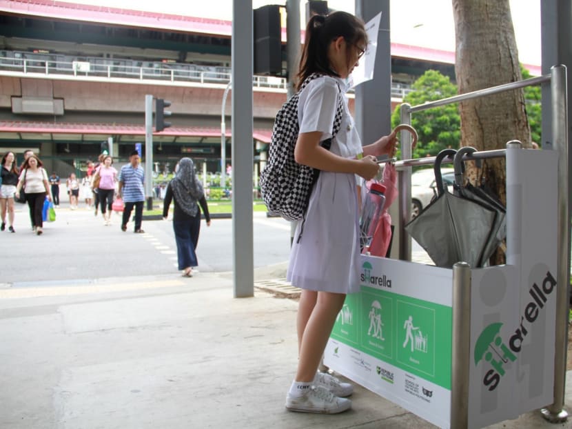 Noelle Neo, 13, taking an umbrella from the umbrella sharing scheme, Sharella's stand at Sembawang MRT station. Photo taken on Aug 22, 2017. Photo: Esther Leong/TODAY