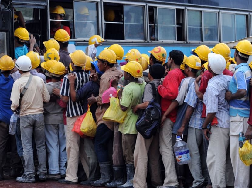 Foreign labourers mainly from Bangladesh board a bus at the end of their shift at a construction site in Kuala Lumpur. Malaysia's aggressive crackdown on undocumented migrant workers that have left many businesses reeling.