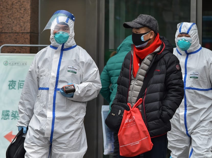 Medical staff wearing clothing to protect against a previously unknown virus walk outside a hospital in Wuhan on January 26, 2020, a city at the epicentre of a viral outbreak that has killed at least 56 people and infected nearly 2,000.