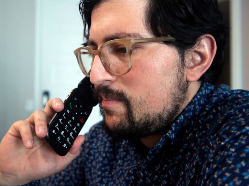 Mr Jose Briones speaks to a coworker while using what he refers to as a dumbphone at his apartment in Littleton, Colorado, on March 24, 2023. 