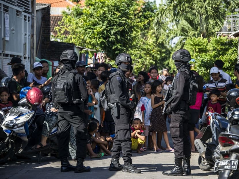 Members of the Densus 88 counter-terrorism police cordon off a road as they search a house in Surabaya, East Java province, on June 19, 2017. Members of the Densus 88 counter-terrorism police cordon off a road as they search a house in Surabaya, East Java province, on June 19, 2017.