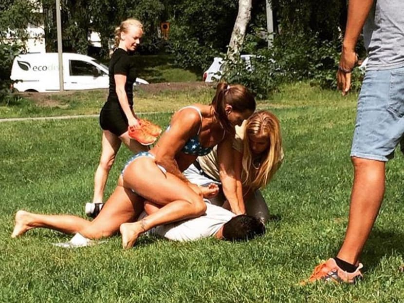 In this photo provided by Jenny Kitsune Adolffson Swedish police officer Mikaela Kellner is pinning a man to the ground who is suspected to have stolen a friend's mobile phone as she said, in Stockholm Sweden, Wednesday, July 27, 2016. She was off duty and wearing a bikini but that didn't stop her from apprehending the man. Photo: Jenny Kitsune Adolfsson via AP
