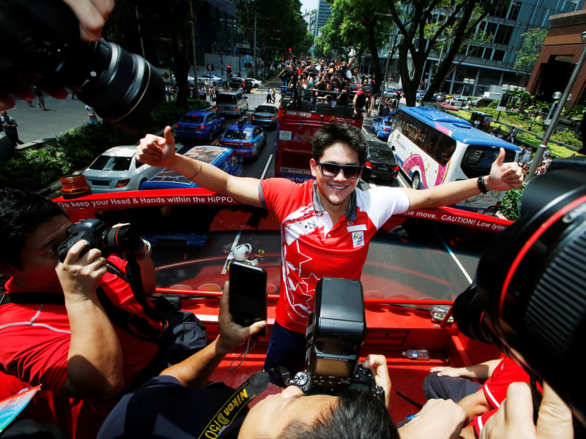 Olympic gold medallist swimmer Joseph Schooling poses for photos during a victory parade on an open top bus along Orchard Road on Aug 18, 2016. Photo: Reuters