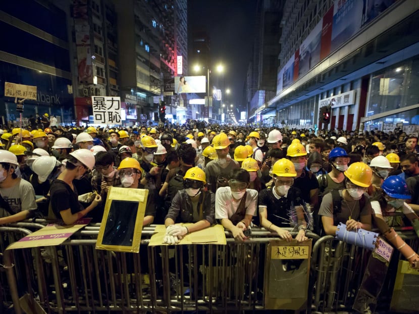 Protesters stand guard behind a barricade at the occupied area in the Mong Kok district of Hong Kong, early Monday, Oct 20, 2014. Photo: AP