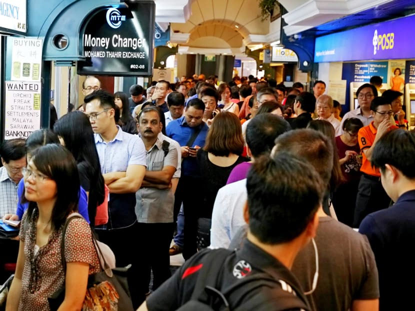 Queues at The Arcade at Raffles Place yesterday after news broke that the Malaysian and Indonesian currencies had plunged to multi-year lows. Photo: Nuria Ling