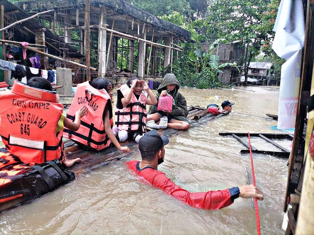 This handout photo taken on April 12, 2022 and received from the Philippine Coast Guard shows coast guard personnel evacuating local residents from their flooded homes on a makeshift raft in the town of Panitan, Capiz province as heavy rains brought on by Tropical Storm Megi inundated the area. This handout photo taken on April 12, 2022 and received from the Philippine Coast Guard shows coast guard personnel evacuating local residents from their flooded homes on a makeshift raft in the town of Panitan, Capiz province as heavy rains brought on by Tropical Storm Megi inundated the area.