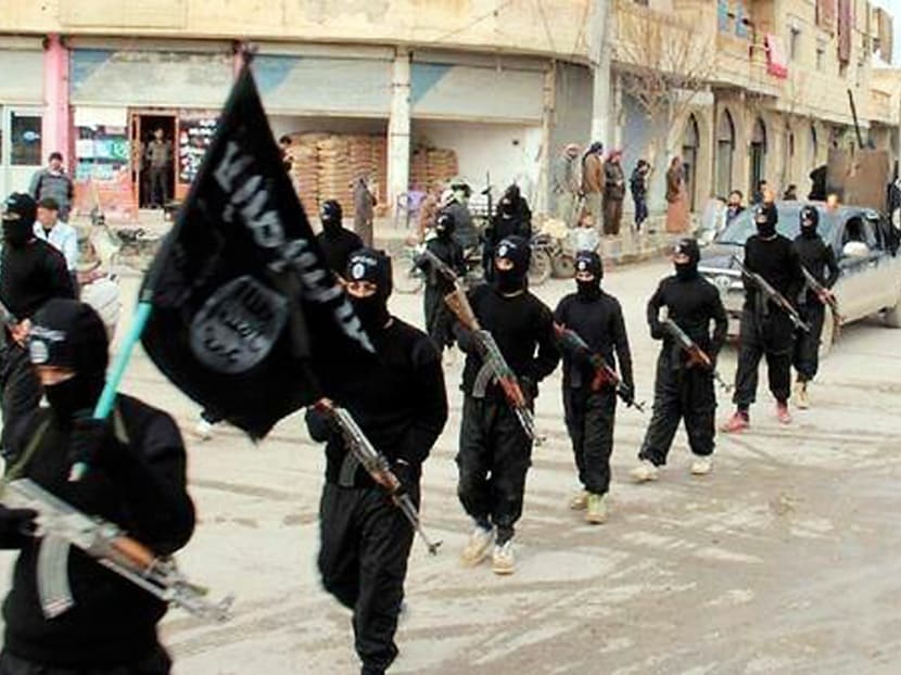 This undated file image posted on a militant website on Tuesday, Jan. 14, 2014, which has been verified and is consistent with other AP reporting, shows fighters from the Islamic State group, marching in Raqqa, Syria. Photo via AP
