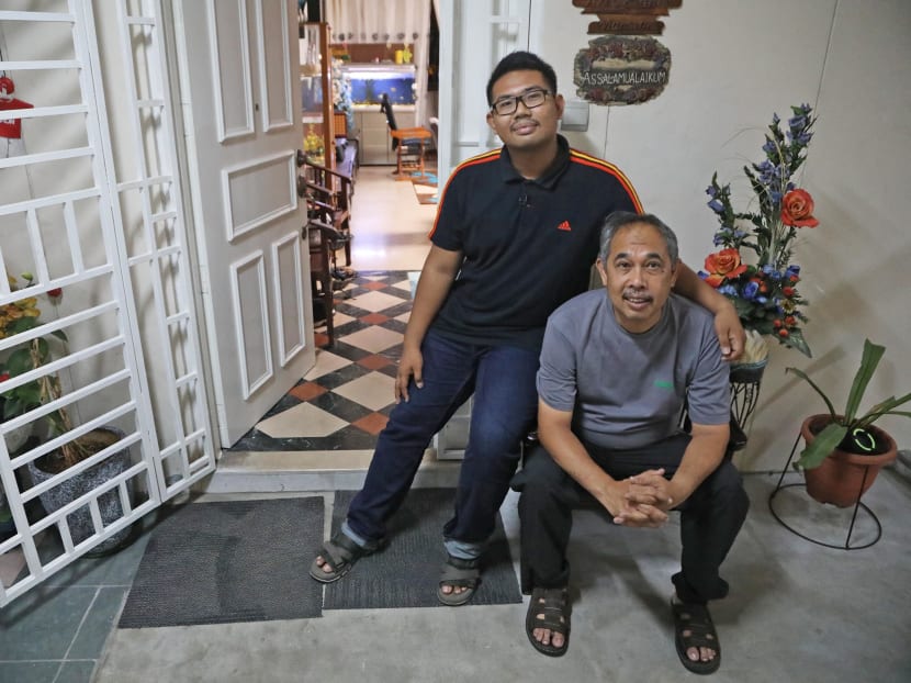 Amir Hamizan Zahare, 21, with his father Zahare Seman, 50. They alerted the police on the alleged ValueMax robber’s bag which was left outside their home in Boon Lay.