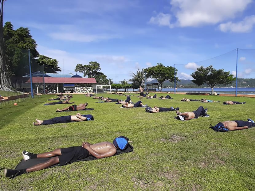 This undated handout photo released on April 17, 2020 by the Indonesian military shows members of an Indonesian Marines defence battalion resting in the sun while observing social distancing amid concerns over the Covid-19 coronavirus outbreak in Ambon, Maluku.
