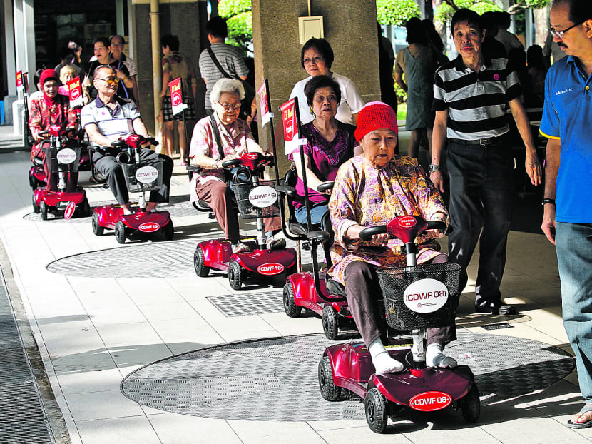 Radin Mas residents trying out motorised scooters on June 9, 2014. Photo: Wee Teck Hian