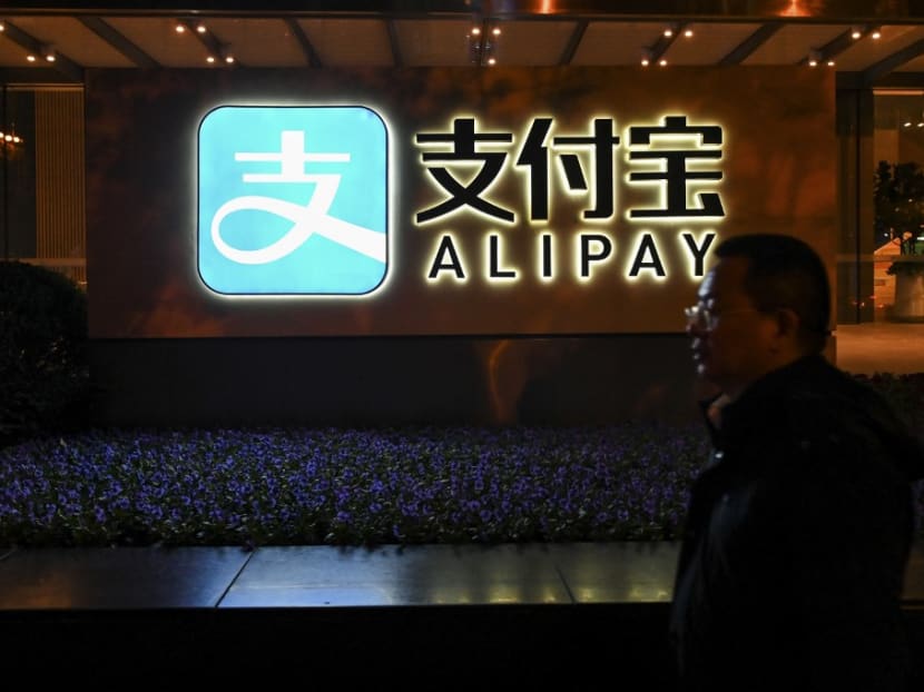 A pedestrian walks past an Alipay logo at the Shanghai office building of Ant Group in Shanghai on Nov 3, 2020. China's Ant Group on Nov 3 suspended its record-breaking IPO in both Hong Kong and Shanghai as the fintech giant faces growing pressure from Chinese regulators over potential risks.