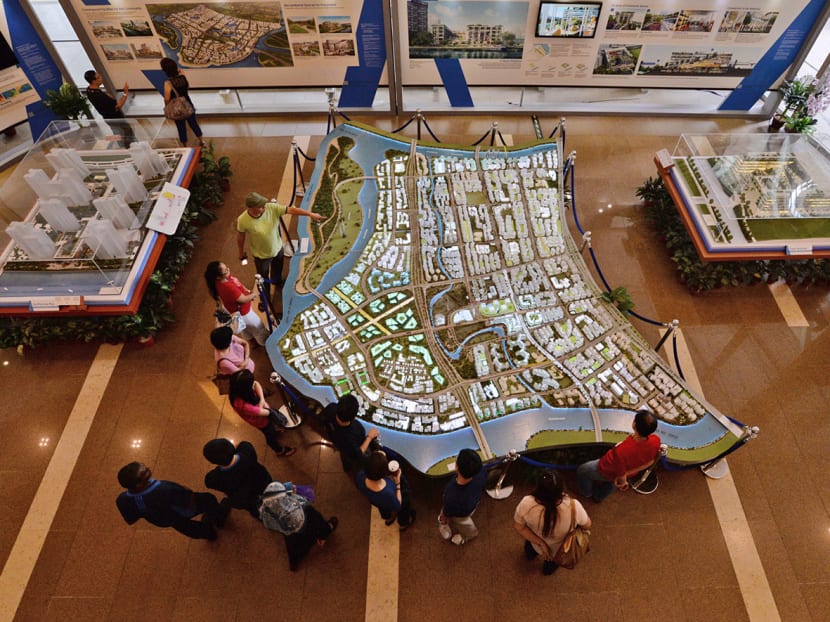 People looking at a model of an upcoming public housing estate. 