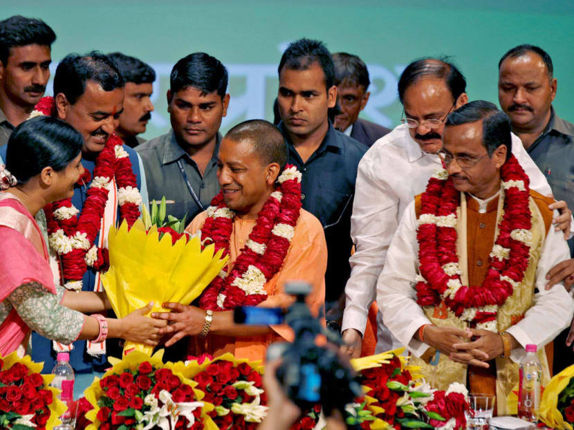 India’s ruling Bharatiya Janata Party (BJP) leader Yogi Adityanath (centre) is presented with flowers after 

he was elected Uttar Pradesh chief minister during the party lawmakers’ meeting on Saturday. Photo: Reuters