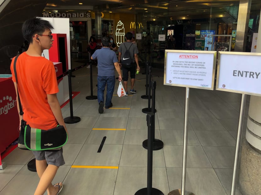 Yellow lines mark out safe-distancing spacing for shoppers in line outside Tampines Mall on March 27, 2020.