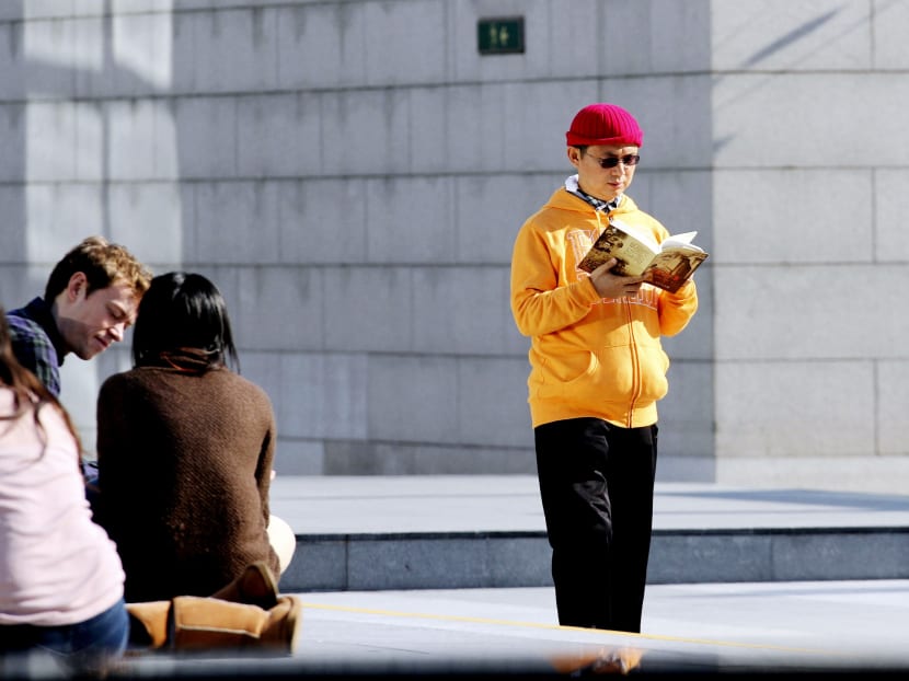 In this Dec 2013 file photo,  Xiao Jianhua, a Chinese-born Canadian billionaire reads a book outside International Finance Centre in Hong Kong. Photo: Next Magazine via AP