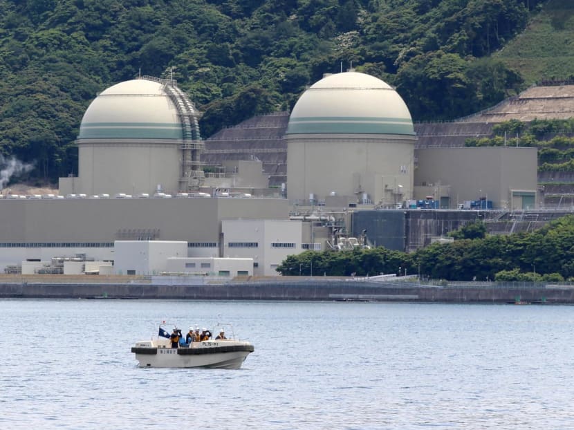 A boat of the Japan Coast Guard patrols in front of the No. 3 reactor (left) at the Takahama nuclear plant in Takahama, Fukui prefecture, some 350 kilometres west of Tokyo on June 6, 2017.